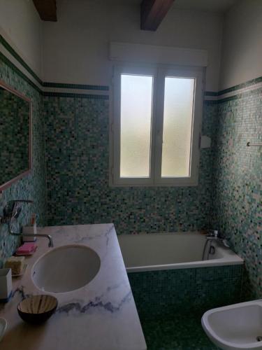 a bathroom with a sink and a tub and a window at Charmante maison avec jardin in Manosque