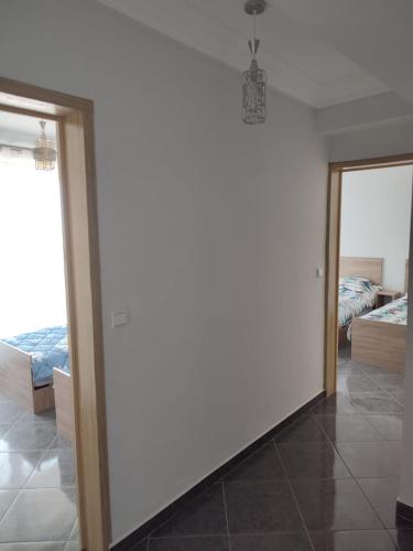 a room with a white wall and a bedroom at Résidence Les Deux Mules in Ahfir