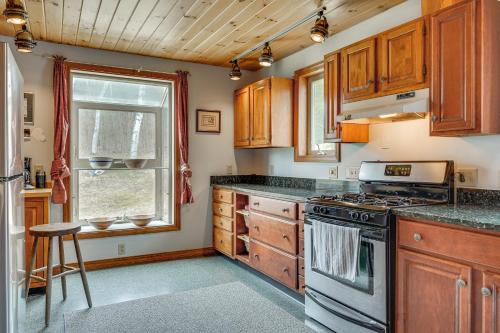 a kitchen with wooden cabinets and a stove top oven at Cozy Home on 10 Acres Yellowstone in Vermont in Townshend