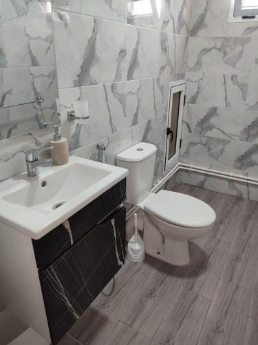 a white bathroom with a sink and a toilet at Résidence Les Deux Mules in Ahfir