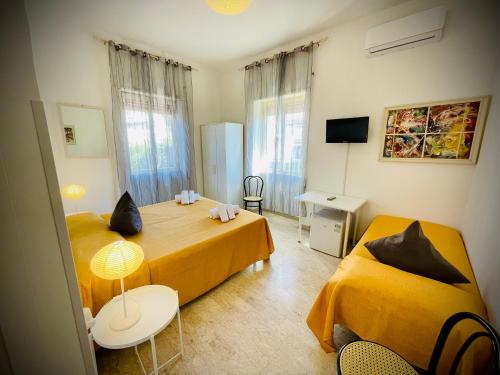 1 Schlafzimmer mit 2 Betten, einem Tisch und Stühlen in der Unterkunft Minturnae Hotel in Scauri