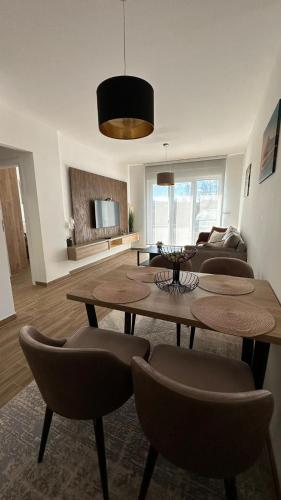 a living room with a table and chairs and a couch at Marshall Apartments - Zlatibor in Zlatibor