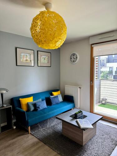 un salon avec un canapé bleu et une table dans l'établissement Studio 2 adultes 2 enfants parcs Disneyland Paris, à Montévrain