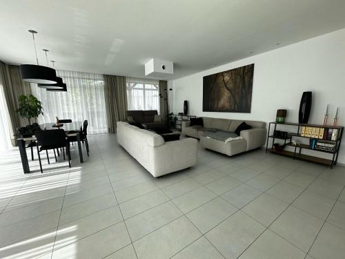 a living room with two couches and a table at Paradies in den Bergen nahe Garmisch Partenkirchen in Eschenlohe