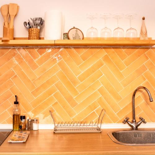 a kitchen with a counter top with a tile wall at Villa Gelsomino in Modica
