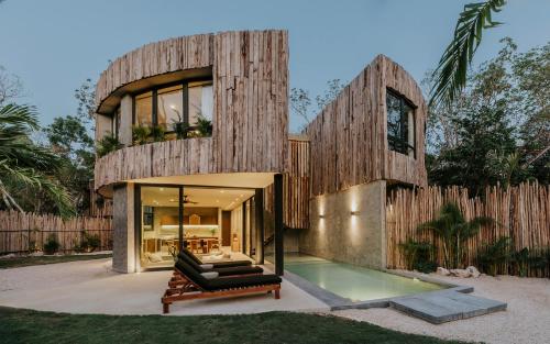 a wooden house with a pool in front of it at Esencia Villas Tulum Priv Pool Concierge in Tulum