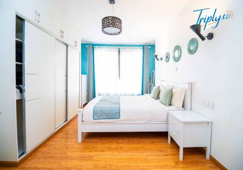 une chambre blanche avec un lit et une fenêtre dans l'établissement Soho B21, à Nairobi