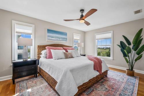 a bedroom with a bed with a ceiling fan and windows at Lowcountry State of Mind luxury beach getaway located on Harbor Island, South Carolina in St. Helena Island