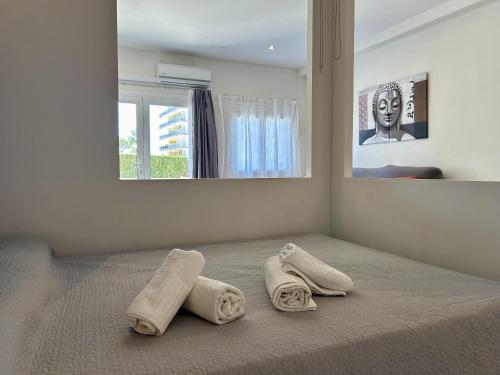 a bedroom with a bed with two towels on it at Loft 'Sol y Sal' Apartamento en primera linea de playa in Miami Platja