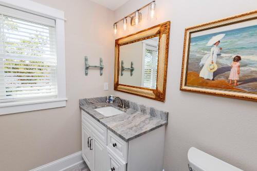 ein Badezimmer mit einem Waschbecken und einem Wandgemälde in der Unterkunft Soundside, Hot Tub, Community Pool, Sound Views, VOH1248, Sunset Cottage in Corolla