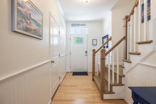 a hallway with white walls and a white door and stairs at Incredible Location in Virginia Beach