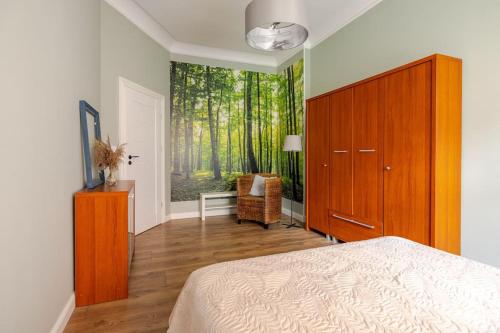 sypialnia z łóżkiem i dużym oknem z drzewami w obiekcie Apartament ROZETA centrum 6os w mieście Legnica