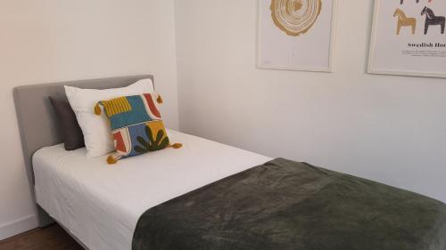 Schlafzimmer mit einem Bett mit weißer Bettwäsche und Kissen in der Unterkunft La Esquina in Denia