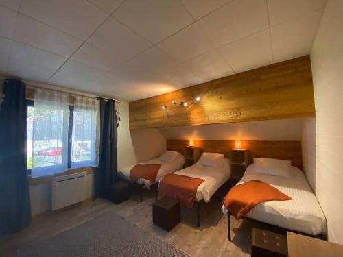 une chambre avec deux lits et une grande fenêtre dans l'établissement Green Valley, à Habère-Lullin