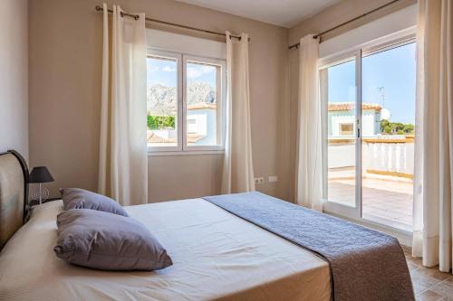 een slaapkamer met een bed en een groot raam bij Villa Primula by Villa Plus in Beniarbeig