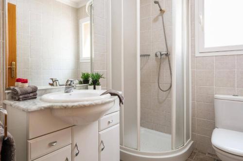 een badkamer met een wastafel en een douche bij Villa Primula by Villa Plus in Beniarbeig