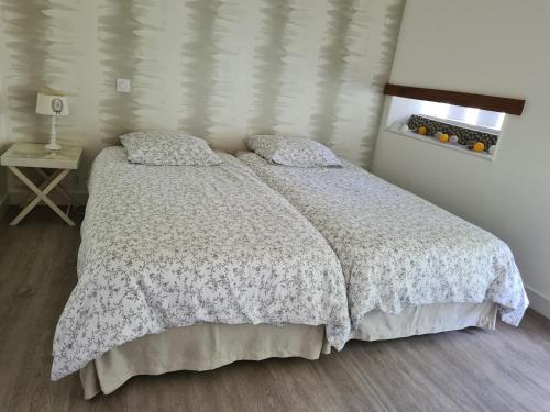 a bedroom with a bed with a white comforter at A la Campagne ,Halte ,Séjour et Détente in Moncontour-de-Poitou