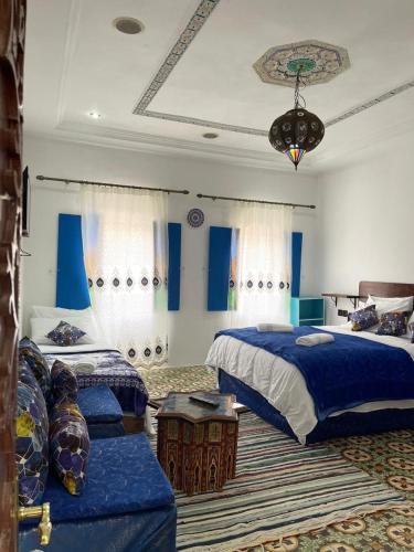 Un dormitorio con dos camas y un sofá. en Riad Blue Oasis, en Fez