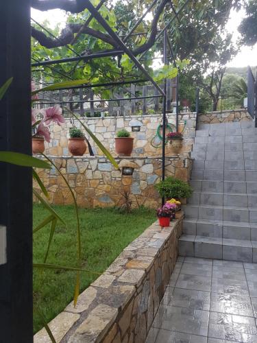 a stone retaining wall and stairs with potted plants at HoneyHouse in Kádhion