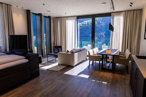 uma sala de estar com um sofá e uma sala de jantar em Grande Fjord Hotel em Geiranger