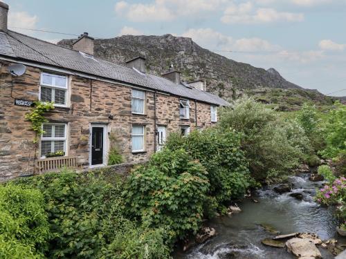 an old stone house next to a river at 3 Barlwyd Terrace in Blaenau-Ffestiniog