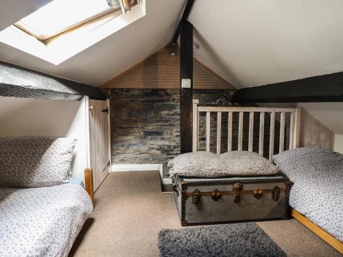 een zolderkamer met 2 bedden en een kofferbak bij 3 Barlwyd Terrace in Blaenau-Ffestiniog