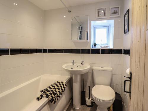 a bathroom with a sink and a toilet and a bath tub at 3 Barlwyd Terrace in Blaenau-Ffestiniog