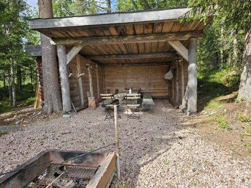 a wooden cabin with a picnic table in the woods at Villa Fregn in Ljørdal