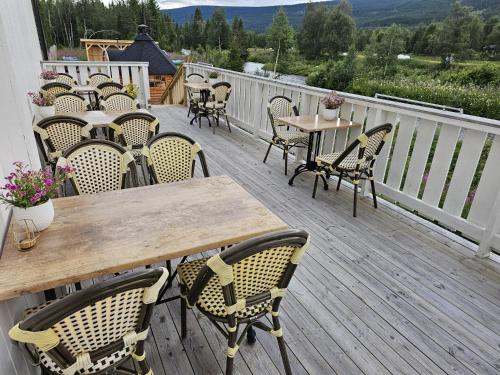 a wooden deck with tables and chairs on a balcony at Villa Fregn in Ljørdal