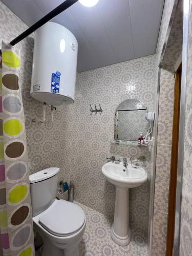 a small bathroom with a toilet and a sink at Hotel Legende in Samarkand