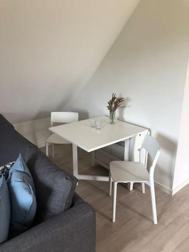 a living room with a white table and chairs at Bjælkehuset in Løkken