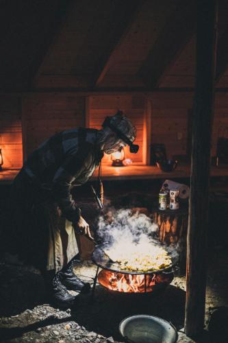 a person cooking food in a pan in a kitchen at Villa Fregn in Ljørdal
