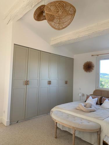 a bedroom with a bed with white cabinets and a window at Villa Boho Cassis in Cassis