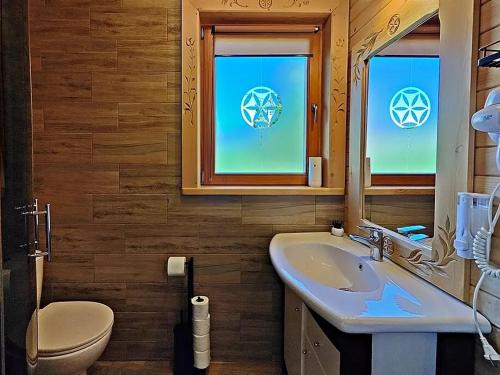 een badkamer met een wastafel, een toilet en een spiegel bij Domek u Śpiewoka 1 in Maruszyna