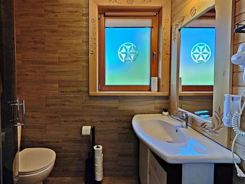 a bathroom with a sink and a toilet and a mirror at Domek u Śpiewoka 1 in Maruszyna