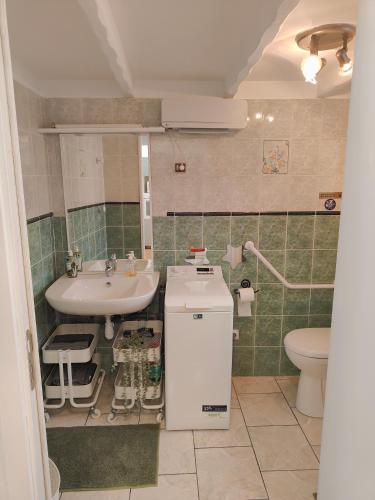 une salle de bain avec un lavabo et des toilettes dans l'établissement Bel appartement avec piscine, à Martigues