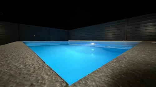 a swimming pool at night with blue illumination at Poolhouse Flip Flop - mit privatem Pool in Vir