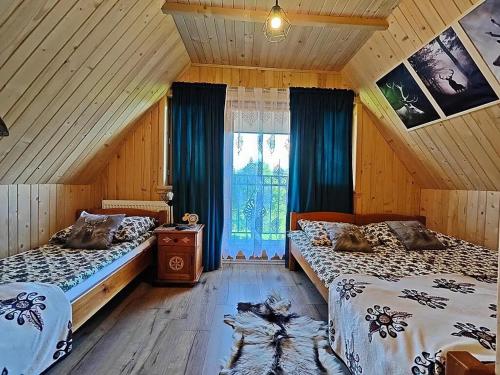 um quarto com 2 camas e uma janela em Domek u Śpiewoka 1 em Maruszyna