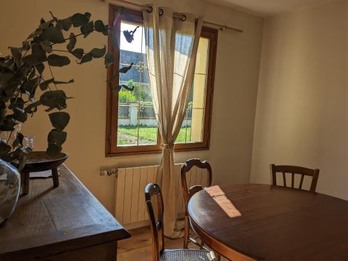 ein Esszimmer mit einem Tisch und einem Fenster in der Unterkunft L'orée du bois in Saint-Valery-sur-Somme