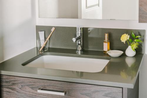 a sink in a kitchen with a black counter top at Sonder at Artesa in Toronto
