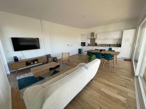 un salon avec un canapé, une table et des chaises dans l'établissement Appartement neuf centre station a 200m de la plage, à Neufchâtel-Hardelot