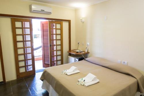 a bedroom with a bed with towels on it at Hotel Fazenda Santa Monica in Louveira
