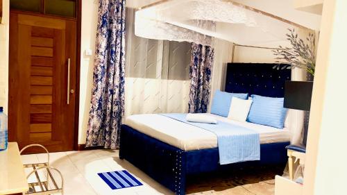 a bedroom with a bed with blue and white at The Pontoons Nyali A103 in Mombasa