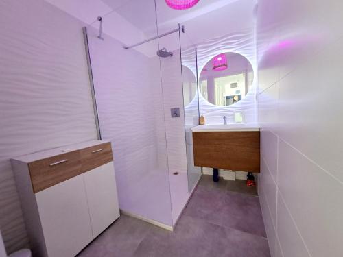 une salle de bain blanche avec un lavabo et un miroir dans l'établissement Appartement T3 de prestige Toulon Cap Brun - proche de la plage, à Toulon