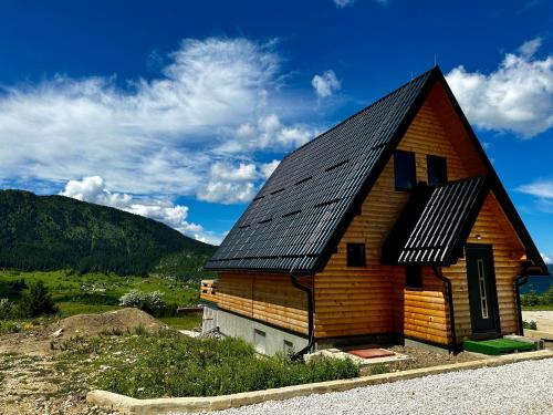 a large wooden house with a black roof at Vlasic Odmor - Villa Vlasicka Bajka in Vlasic