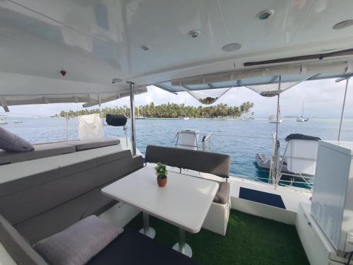 a white boat with a table on the water at Private Catamarán With Crew - DON C - Lagoon 40 feet - All Inclusive in Isla Wichitupo Grande