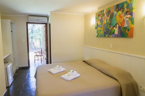 a bedroom with a bed with two towels on it at Hotel Fazenda Santa Monica in Louveira