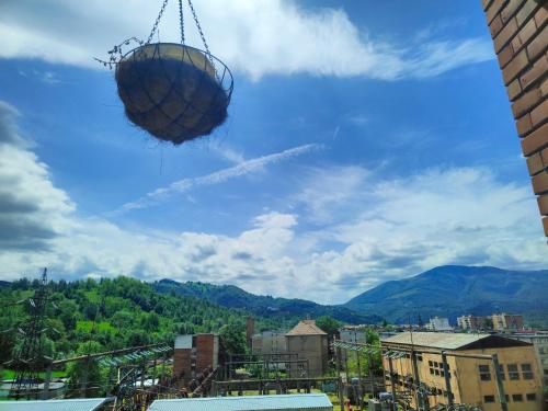 a basket is suspended in the sky over a city at Mountain View Apartment in Petroşani