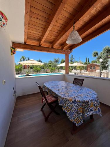 a table and chairs on a balcony with a view of the ocean at Villa Paternelli in Bisceglie