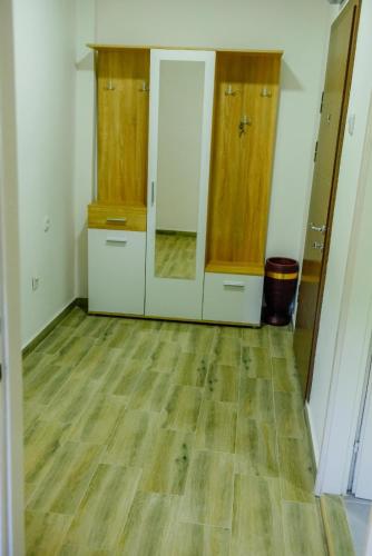 an empty room with wooden floors and cabinets at Panorama Plužine Apartment in Pluzine